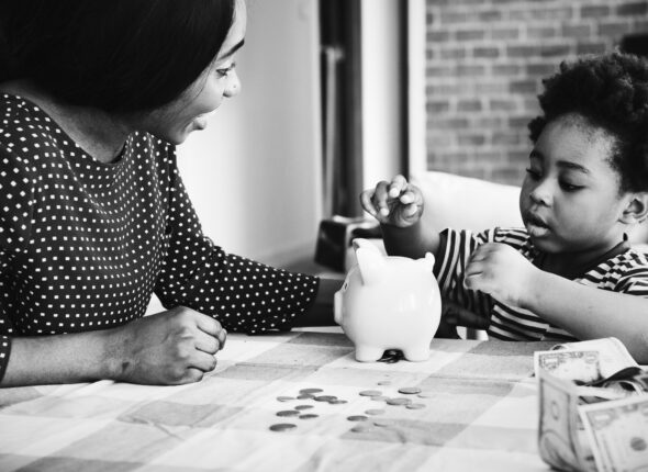 Mom and son saving money to piggy bank